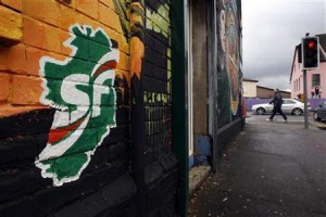 Sinn Fein graffitti is seen painted on the wall of a shop on the Beechmount Parade near the Falls road in West Belfast