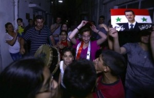 Varios ciudadanos festejan en las calles la victoria de Al-Assad. Foto: Louai Beshara