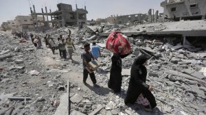 Palestinos cargan con objetos personales que han logrado salvar de sus casas destruidas en los bombardeos del barrio de Beit Hanún (1 de agosto de 2014). Foto: Lefteris Pitarakis