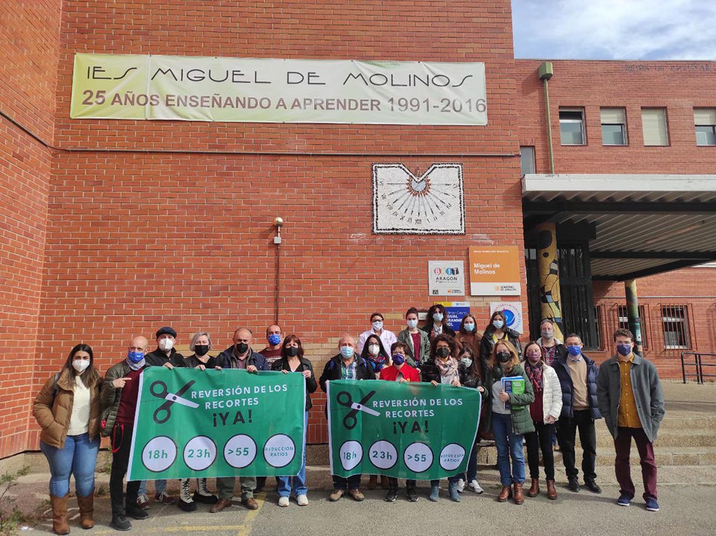 Varias personas se concentran en la fachada del IES Miguel de Molinos de Zaragoza dentro de la campaña de movilizaciones de los sindicatos STEA y CGT, con pancartas en las que se leen lemas sobre la reversión de los recortes