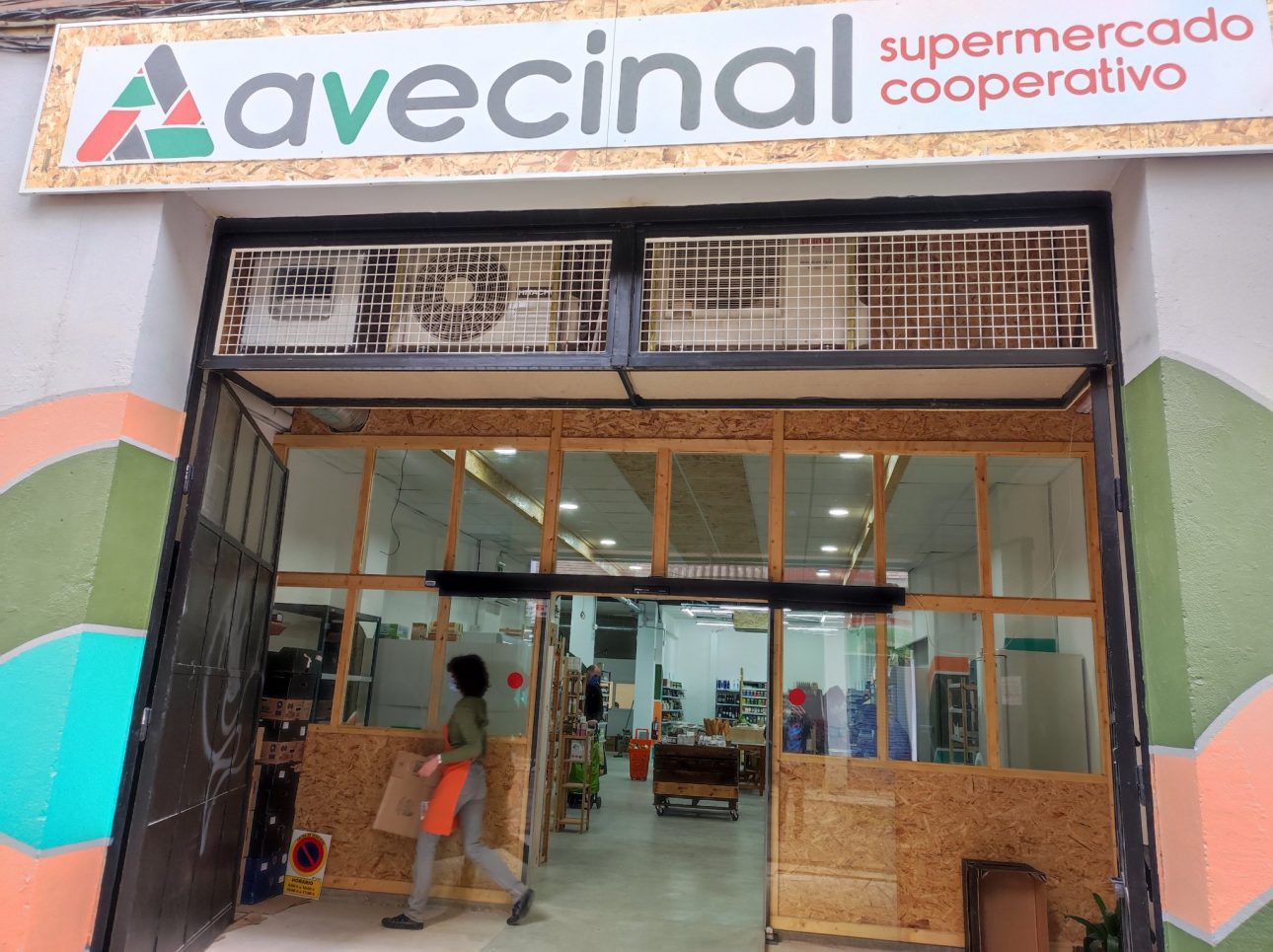 Entrada del supermercado A Vecinal con un letrero y las puertas de madera