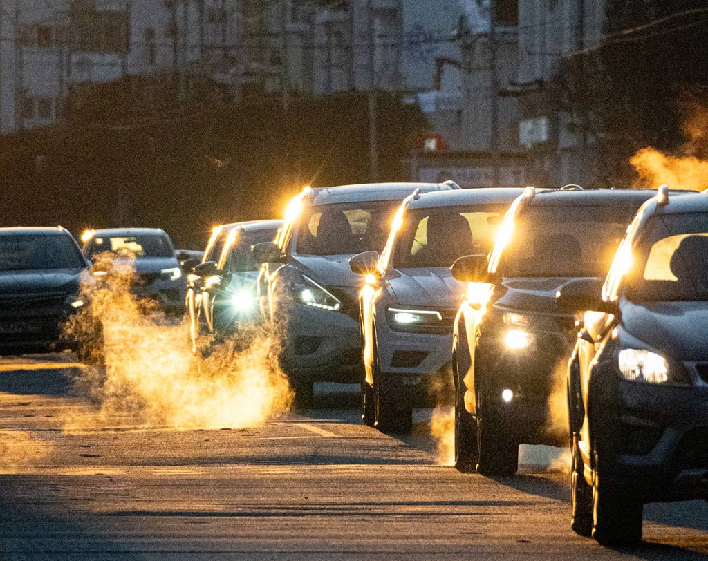 Coches en la carretera soltando gas por los tubos de escape y empeorando el aire