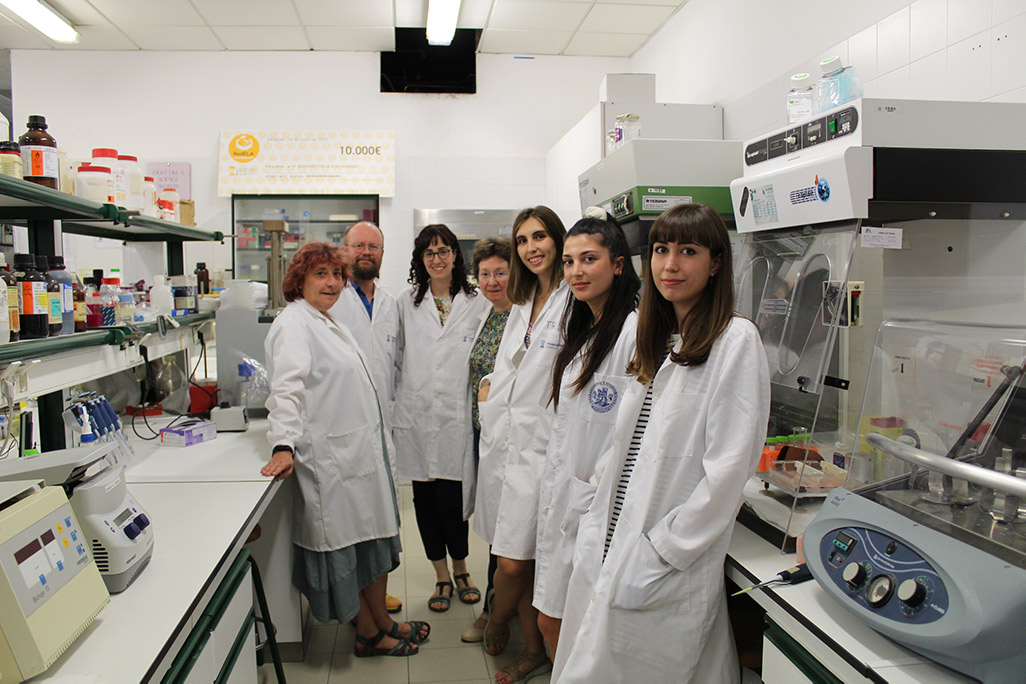 Un grupo de siete científicas en su laboratorio con bata blanca