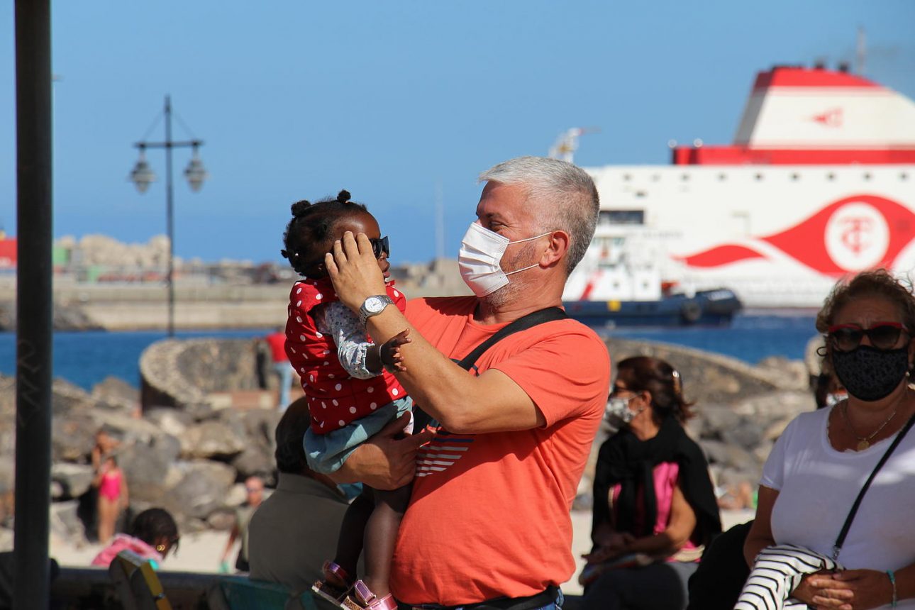 Un hombre sostiene a una niña en Canarias en una manifestación por los derechos de las personas refugiadas