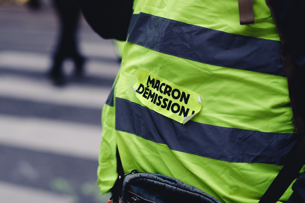 Un chaleco amarillo donde se lee 'Macron dimisión' en francés en una marcha de la izquierda francesa