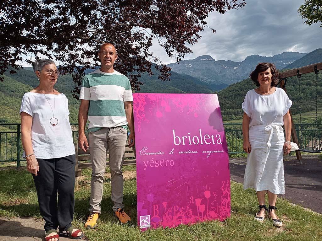 Tres personas junto al cartel de este año de Brioleta