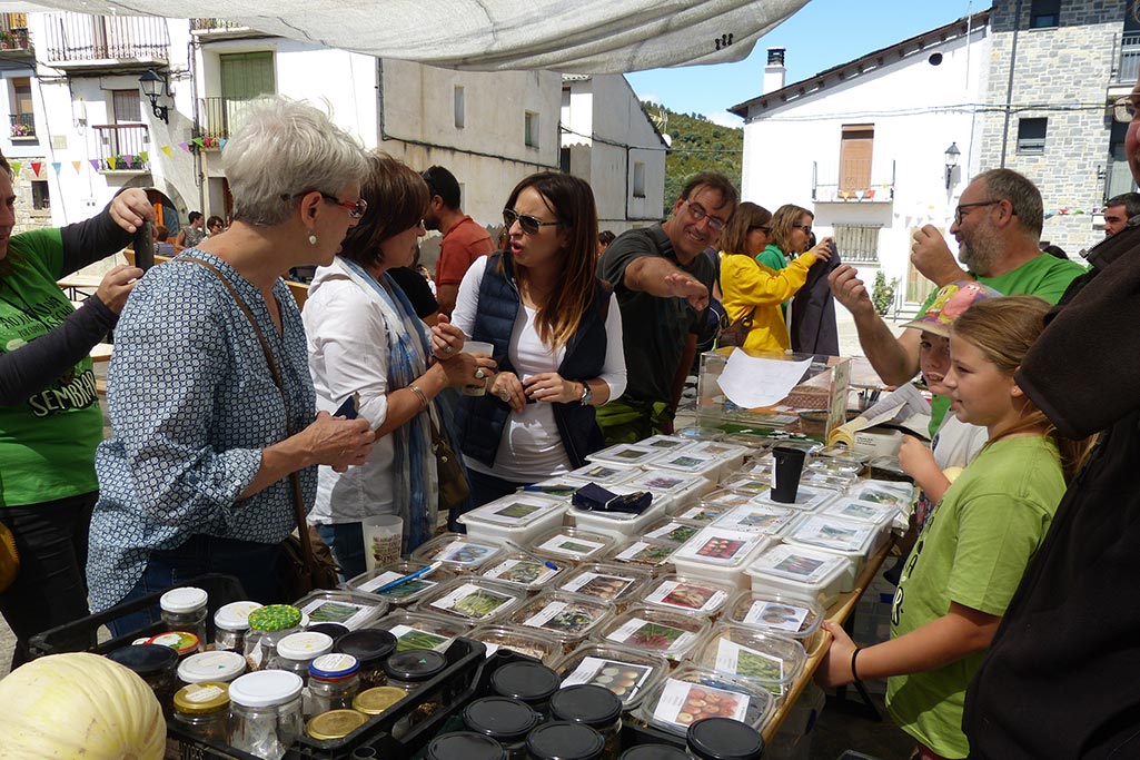 un puesto con varias personas alrededor viendo productos agrícola