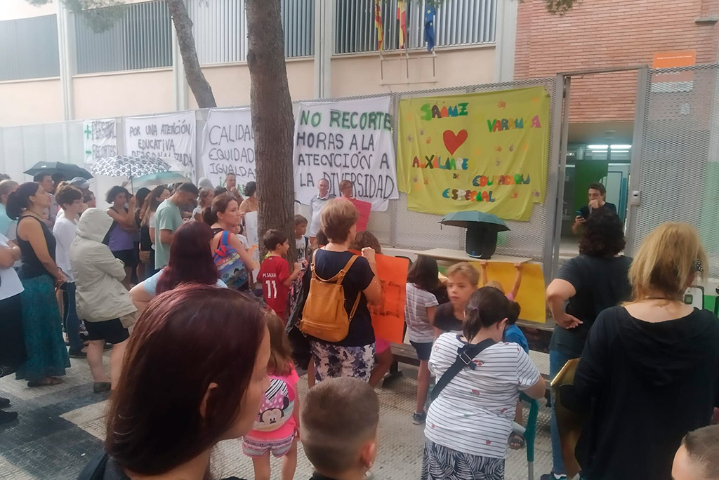 varias personas frene al colegio de torrero con carteles