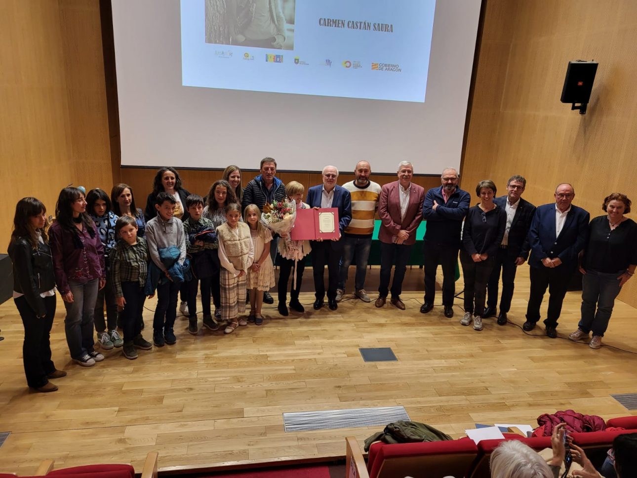 varias personas con Carmen en el centro con el premio