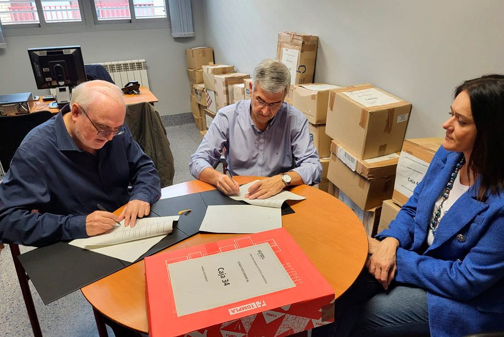 tres personas de la academia firmando unos papeles