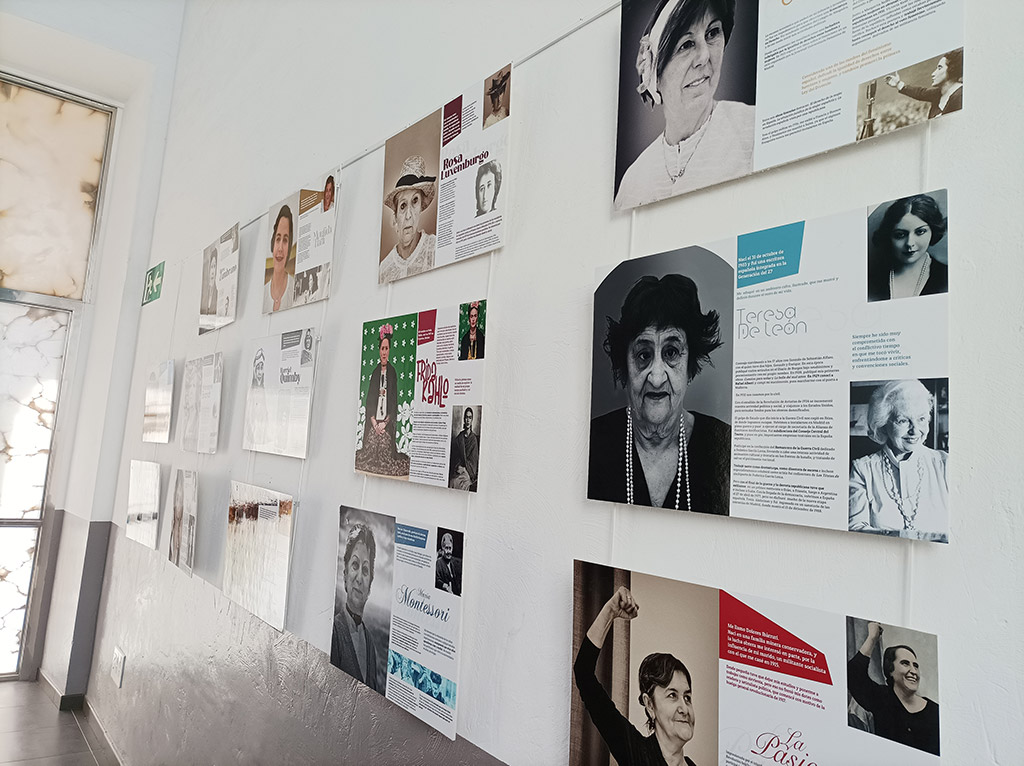 Carteles de la Exposición Mujer ilustre alumna ilustre en una pared