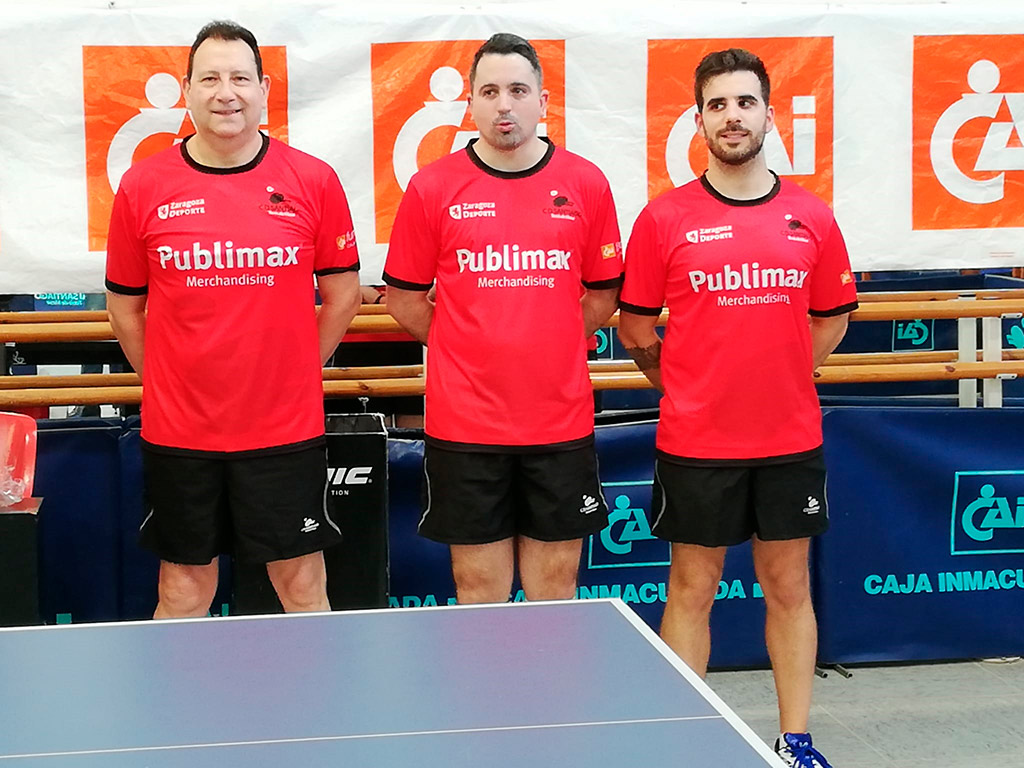 tres jugadores del publimax cai santaigo de zaragoza posan frente al tablero de tenis de mesa con sus equipaciones