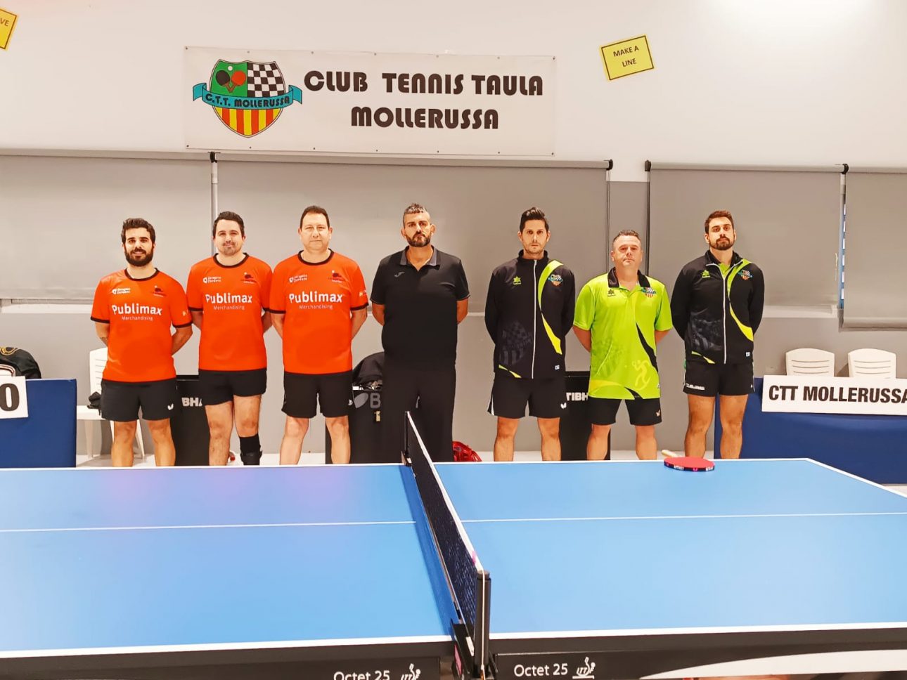 Jugadores del Publimax CAI Santiago de tenis de mesa frente al tablero tras una victoria