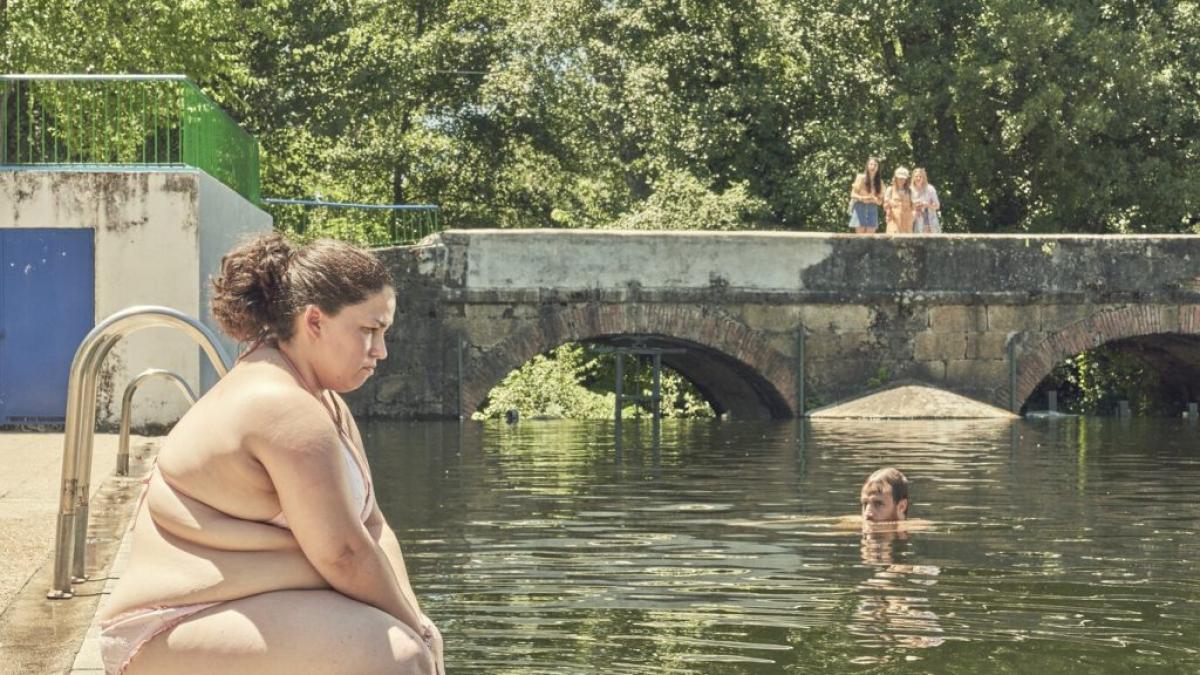 fotograma de cerdita, nominada a los premios feroz, donde una chica esta sentada en el borde de una piscina