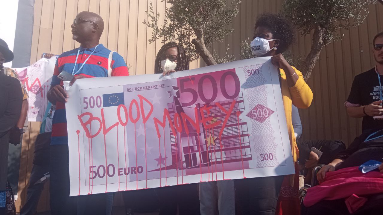 cartel con un billete de 500 euros que pone blood cambio climático