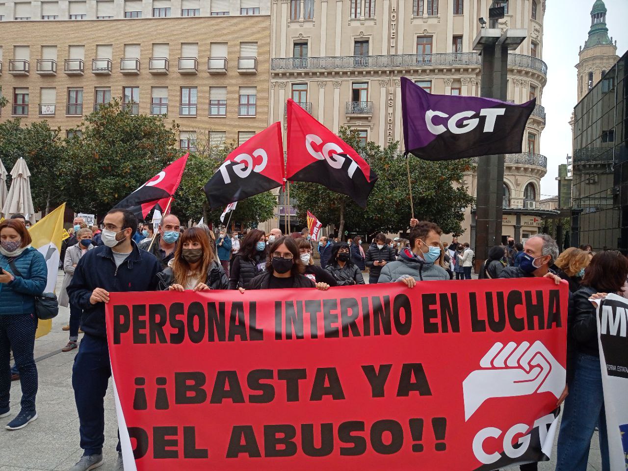 varias personas en abuso de temporalidad con una pancarta