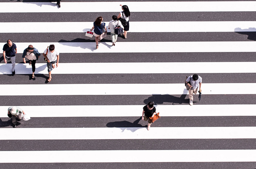Gente andando por un paso de cebra por la calle desde arriba en una ciudad para ilustrar una noticia sobre AIDS SIDA VIH
