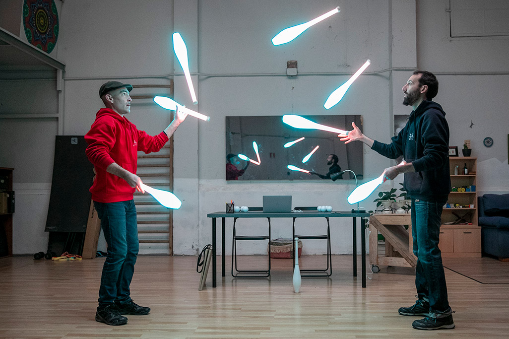 circo dos personas haciendo malabares con objetos con luz