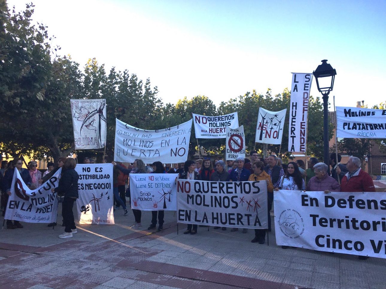 varias personas con carteles en una concentración en contra de los aerogeneradores