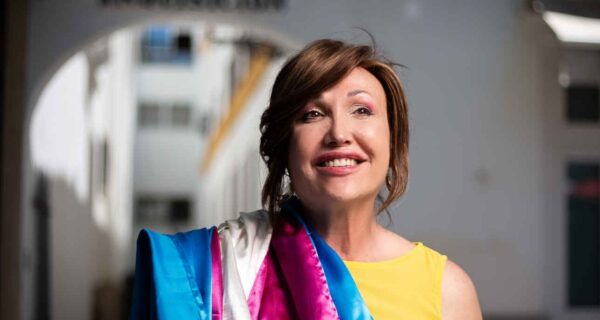 Mar Cambrollé, presidenta de la Federación Plataforma Trans, con la bandera trans al hombro en una imagen vinculada a la defensa de los derechos del colectivo LGTBIQA+.