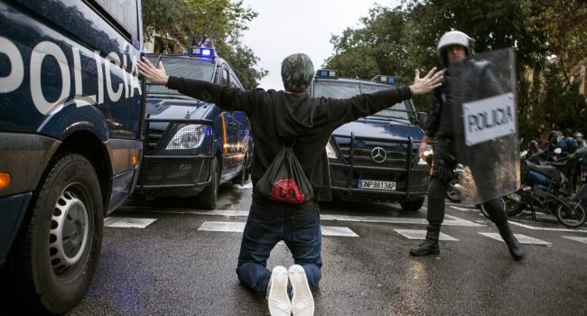 Un manifestante entre los furgones de la Policía española. Foto: Jone Arzoz (El Salto)
