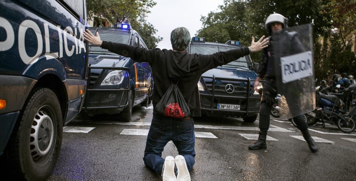 Un manifestante entre los furgones de la Policía española. Foto: Jone Arzoz (El Salto)
