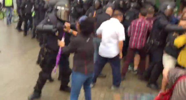 Captura de vídeo de  @AgenciaUO en la que se ve a un agente de policia golpeando a una manifestante en la cara con la porra.