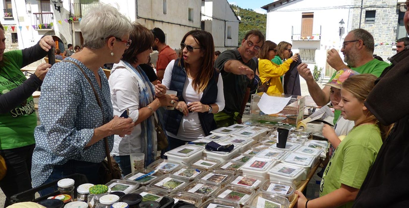 un puesto con varias personas alrededor viendo productos agrícola