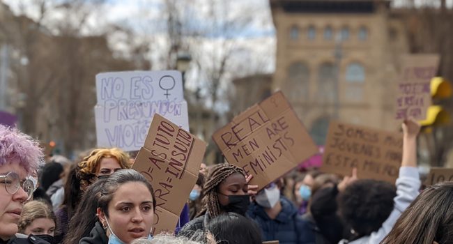 carteles en los que pone real men are feminist y otros en contra de la violencia sexual