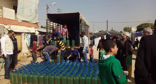 Miembros de ARAPAZ reparte gasoil en el campo de refugiados sirios de Chatura.