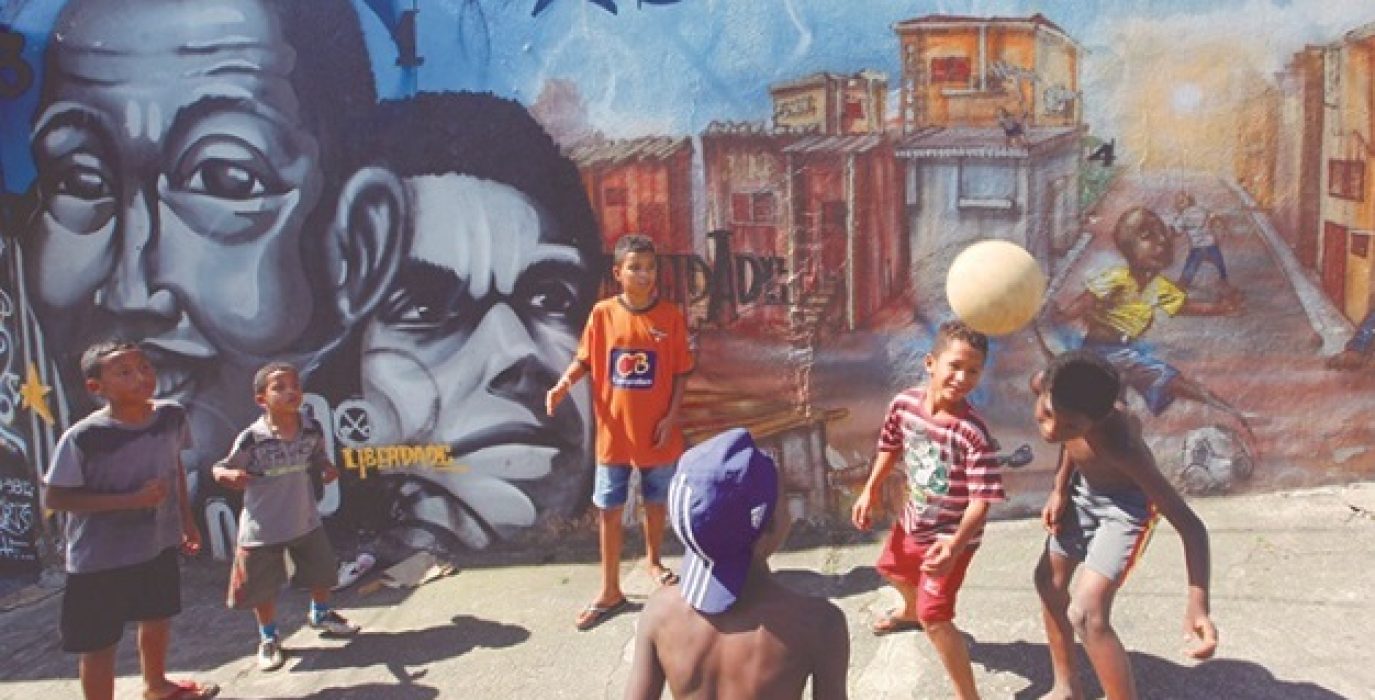Children play in front of graffiti painted by artists of OPNI in the Vila Flavia favela of Sao Paulo