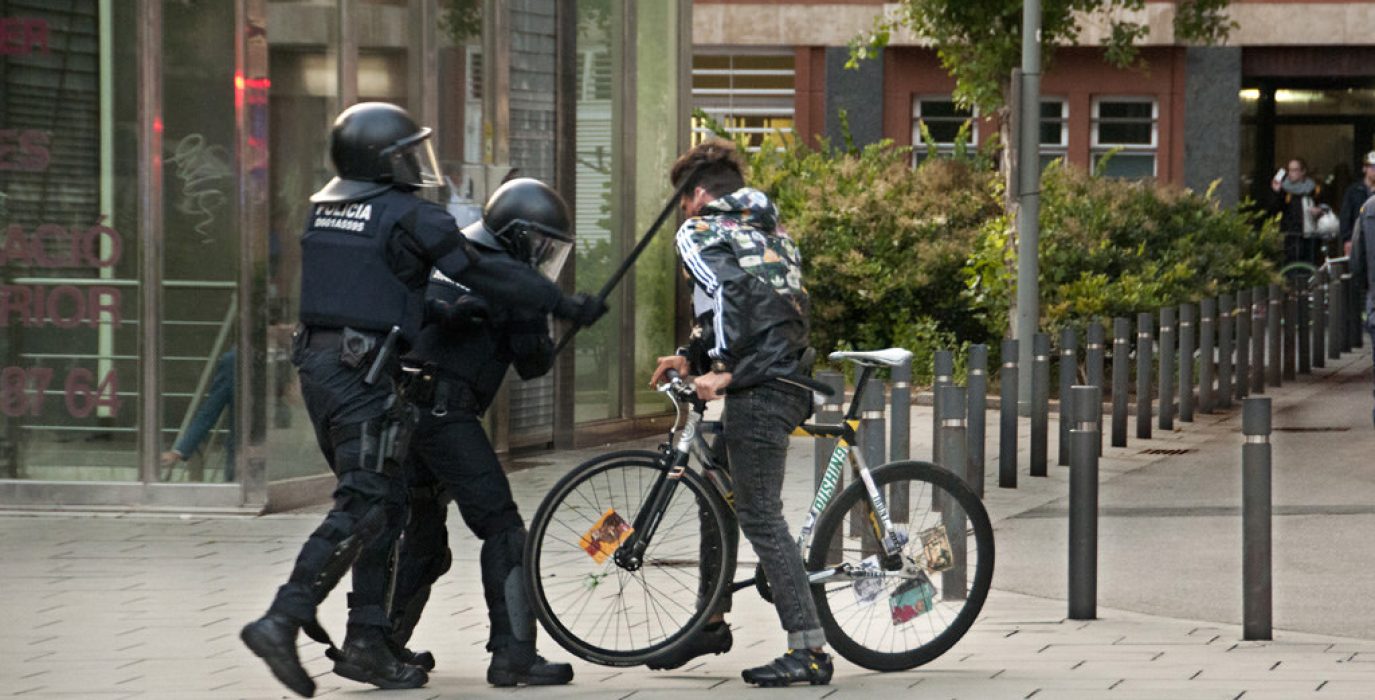 Antidisturbios de los Mossos cargan contra un joven que tuvo que ser atendido por un corte en la oreja, ayer en Sants. Foto: Pedro Mata (Fotomovimiento)
