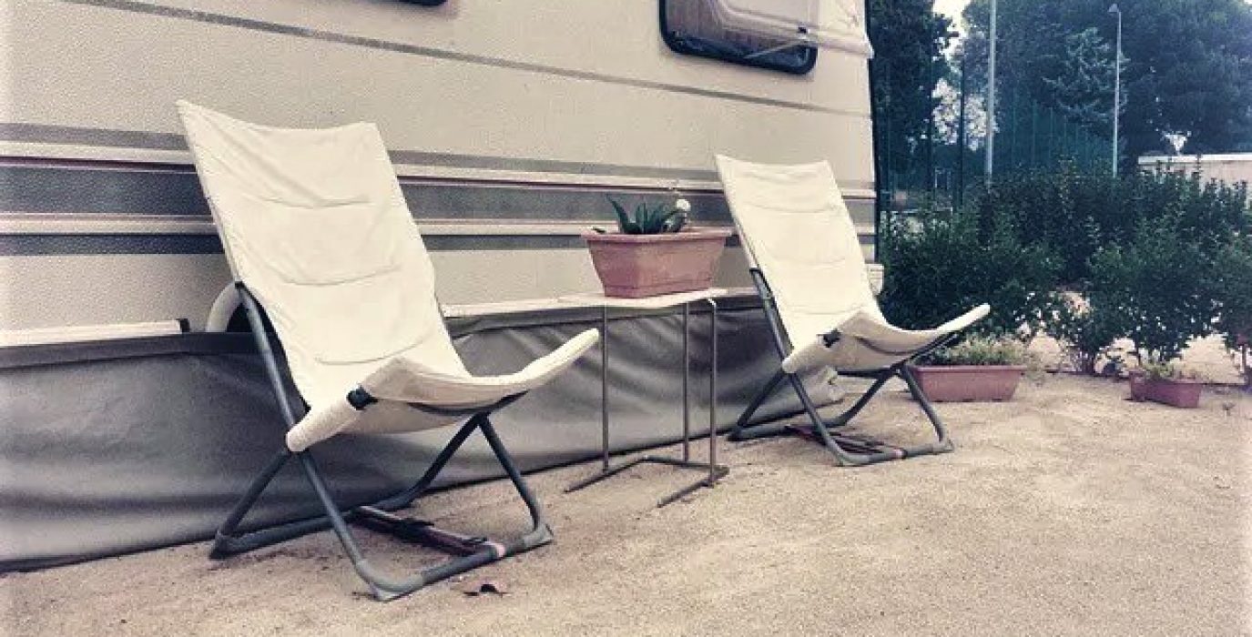 Dos sillas vacías junto a una caravana en el Camping de Zaragoza