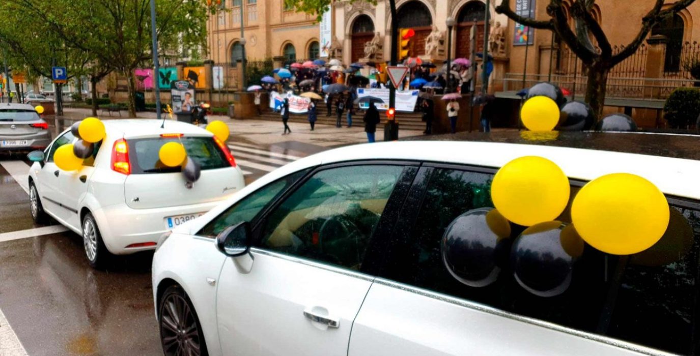 La caravana de coches de la plantilla interina a su paso por el Paraninfo en Zaragoza.