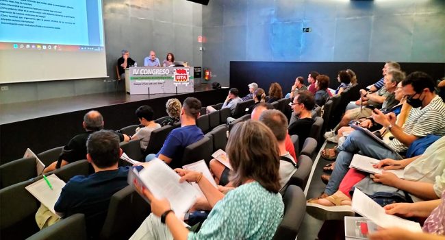 Personas que conforman los seis sindicatos de Intersindical ISTA en un anfiteatro con sus representantes en la mesa