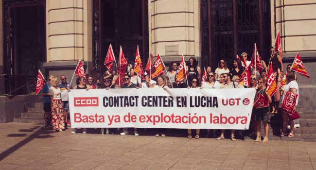 Un grupo de trabajadores de contact center en una concentración con una pancarta
