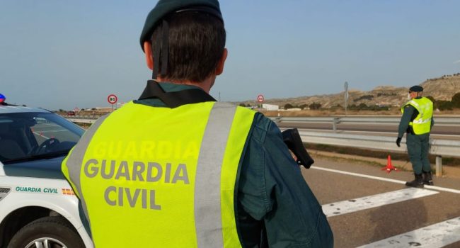 dos guardias civiles dan el alto a los coches en una carretera durante la semana santa