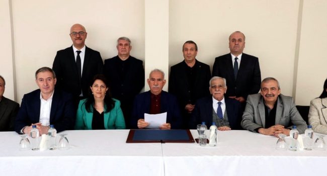 Abdullah Öcalan, en el centro de la imagen en su primera fotografías en varios años, junto a la delegación del partido DEM, en la isla-prisión de Imrali, donde leyó la histórica declaración | Foto: Centro Info Kurdistán