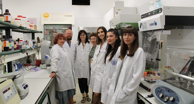 Un grupo de siete científicas en su laboratorio con bata blanca