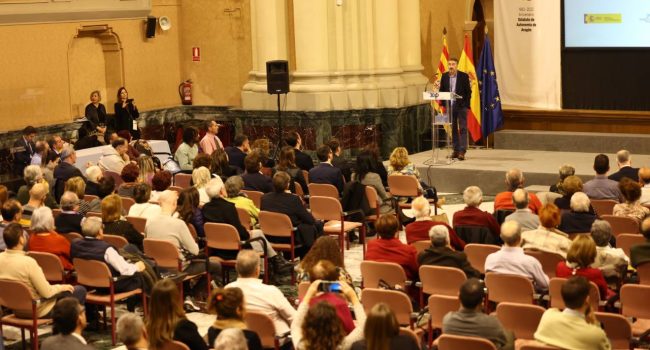 Una sala llena de gente con una mujer de la fundación picarral hablando en un atril