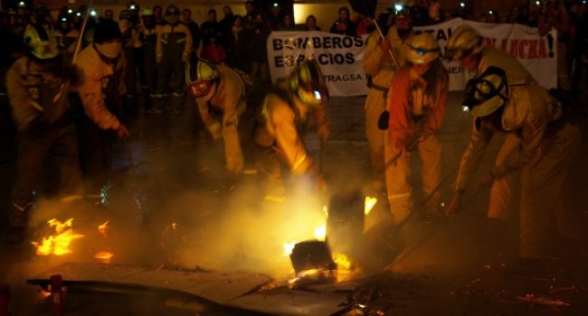 Bomberos Forestales de ambas empresas apagando con sus batefuegos la simbólica 'Ley de montes'. Foto: Miguel Ángel Conejos