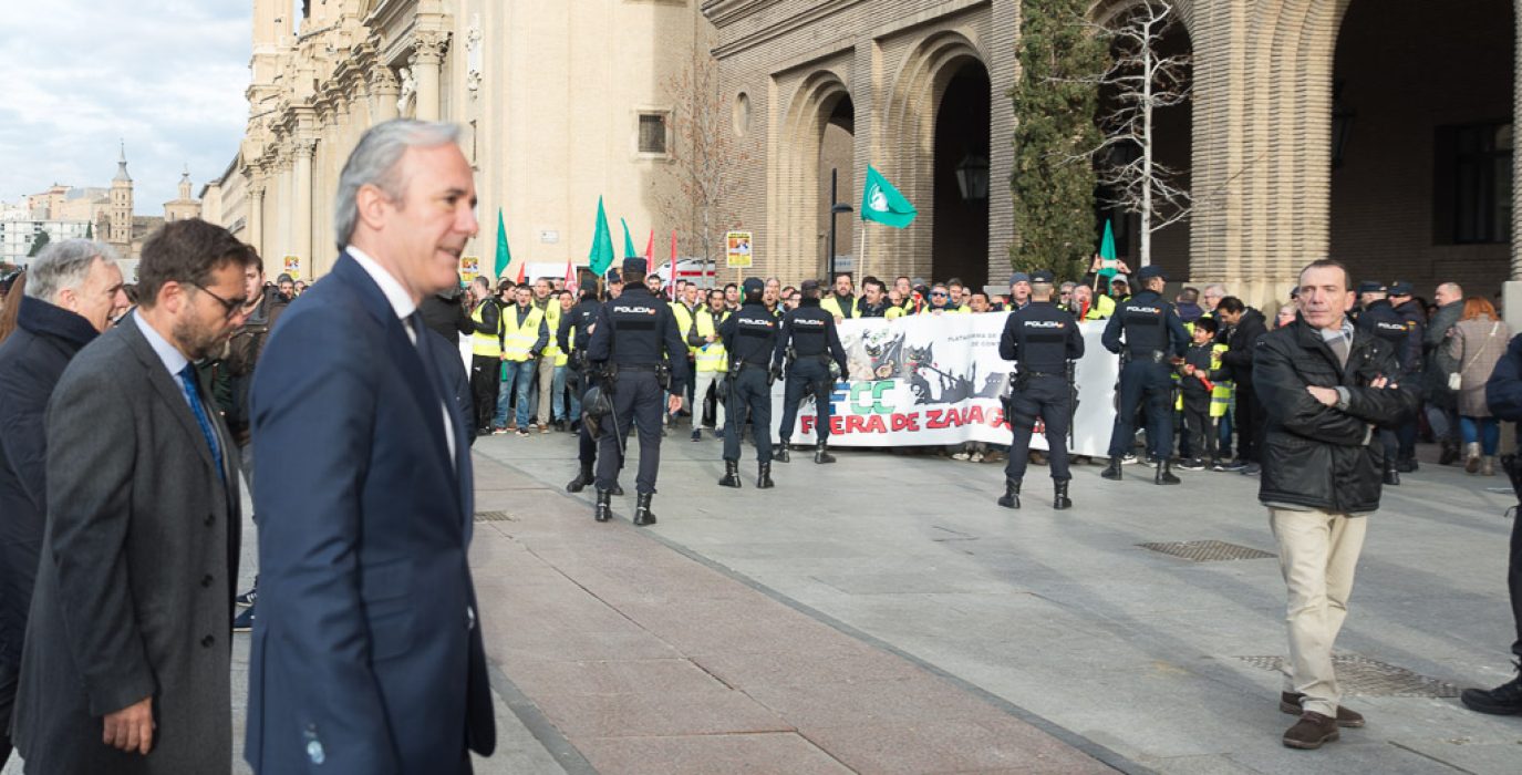 En primer plano el alcalde de Zaragoza Jorge Azcón, al fondo la plantilla de Parques y Jardines protestando en el día de San Valero.
Foto: Pablo Ibáñez (AraInfo)