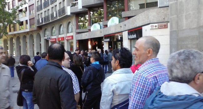 Decenas de personas hacen fila para ser atendidos por Kutxabank. La entidad ha cerrado la oficina al público. Foto: Podemos Zaragoza