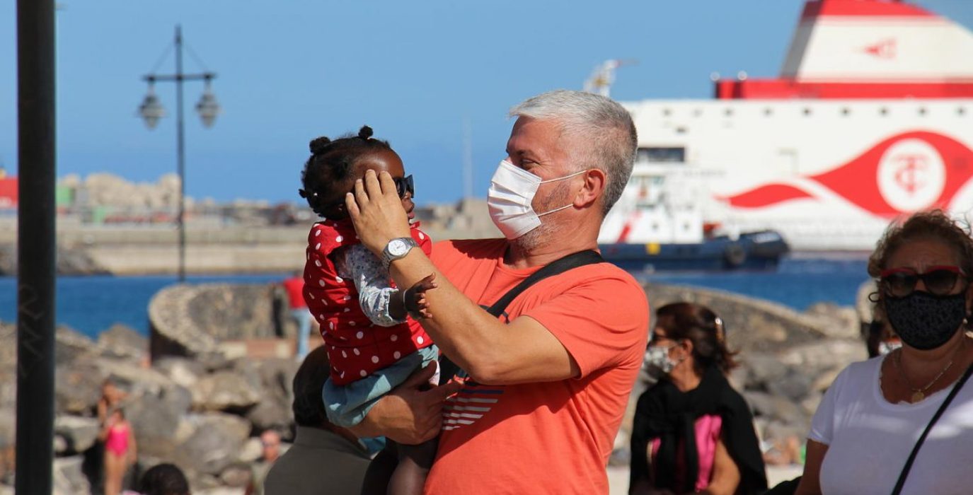 Un hombre sostiene a una niña en Canarias en una manifestación por los derechos de las personas refugiadas