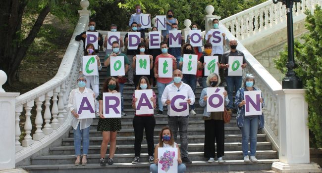Maru Díaz, en primera fila sentada en el suelo, junto a sus compañeras y compañeros de candidatura. Foto: @PodemosContigoA