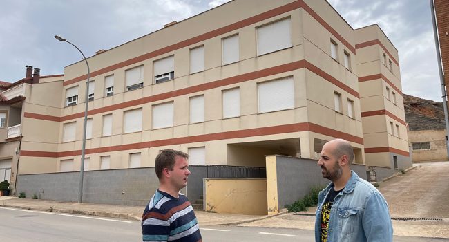 Nicolás López (dcha.) y Pablo Cercos, número 3 en la lista de la formación, frente a un bloque de pisos propiedad de SAREB en Villaspesa | Foto: Ganar Teruel