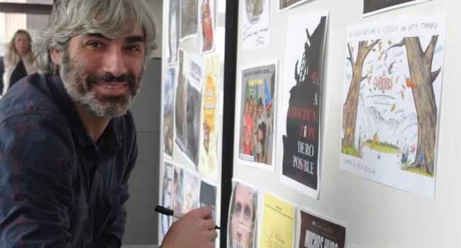 Saúl M. Iragaray firma en el cartel de su película Lo Gorroroi, antes de la presentación.