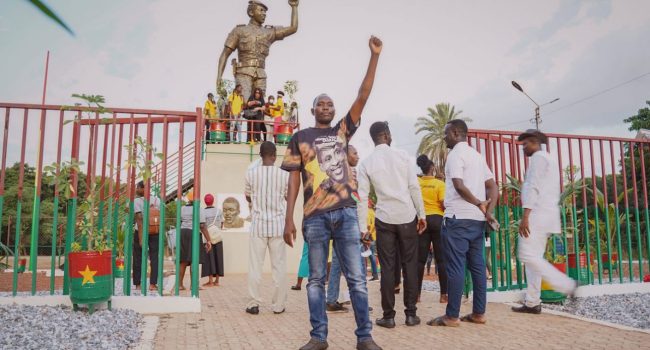Un joven levanta el puño ante la estatua de Thomas Sankara. Foto: Àlex Verdejo (Directa)