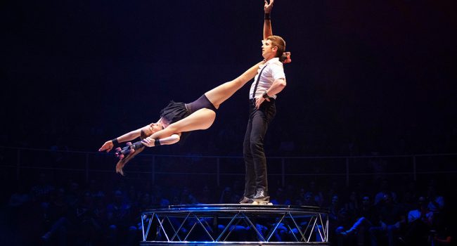 dos personas haciendo acrobacias de circo en patines