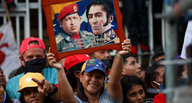 Una venezolana porta los retratos de Hugo Chávez y Simón Bolivar. Foto: PSUV